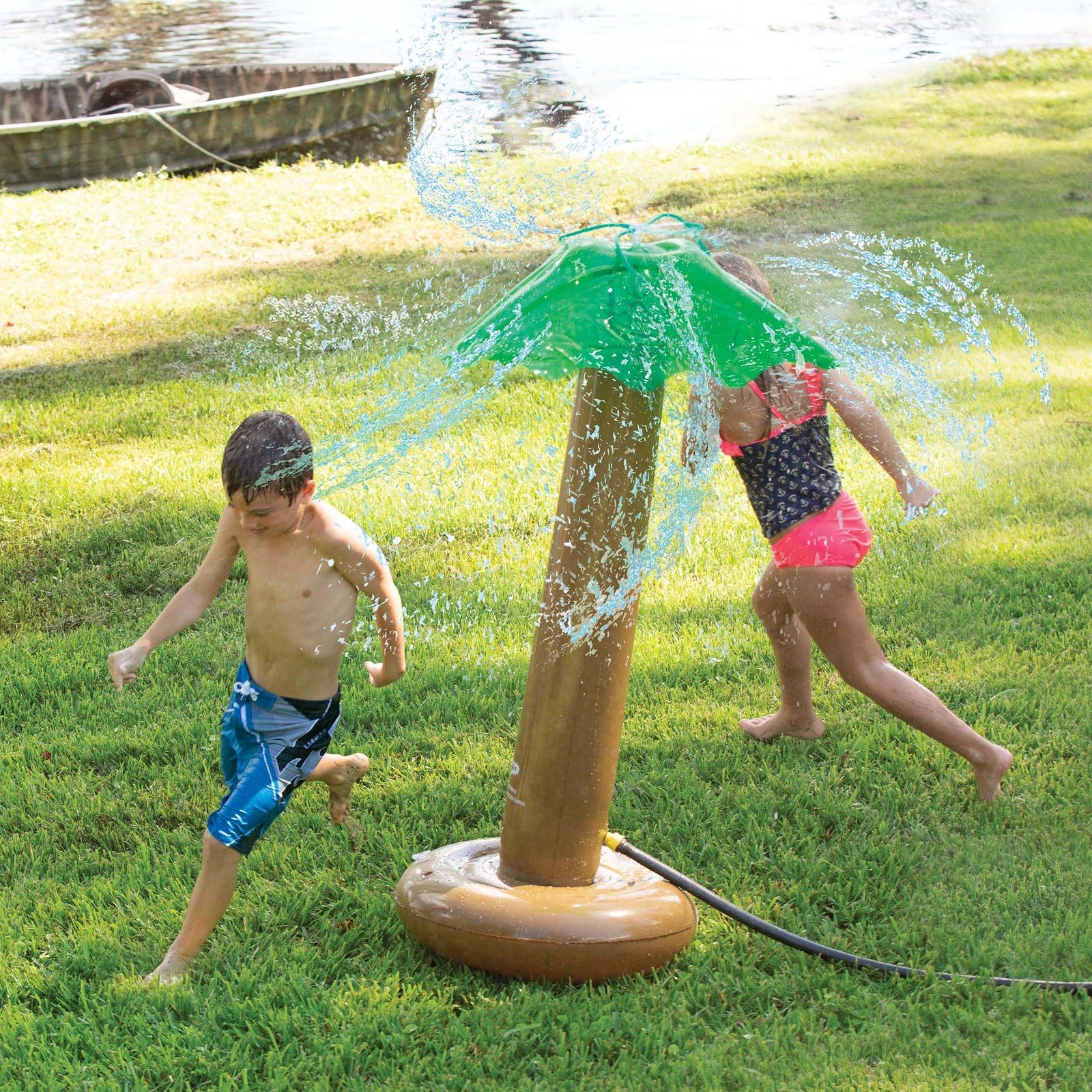 Kids playing in a Giggle ’N Splash palm tree sprinkler