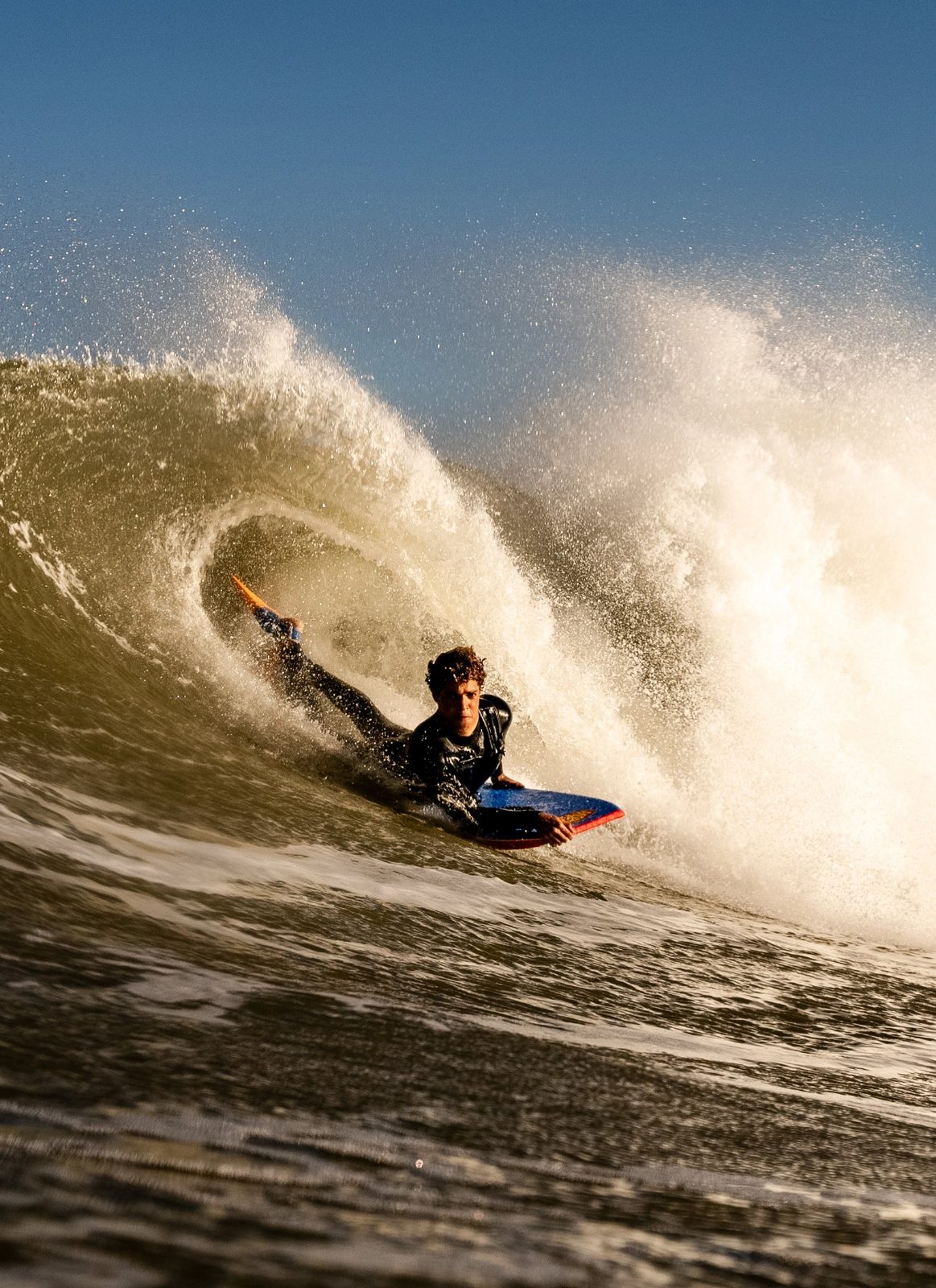 Bodyboarder riding a Morey board in a breaking wave